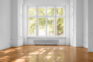 large window in empty old apartment building with parquet flooring