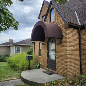 Custom awning at a home in Quincy, IL by Mr. K's Fabric Shop. Explore custom window treatments and upholstery services.